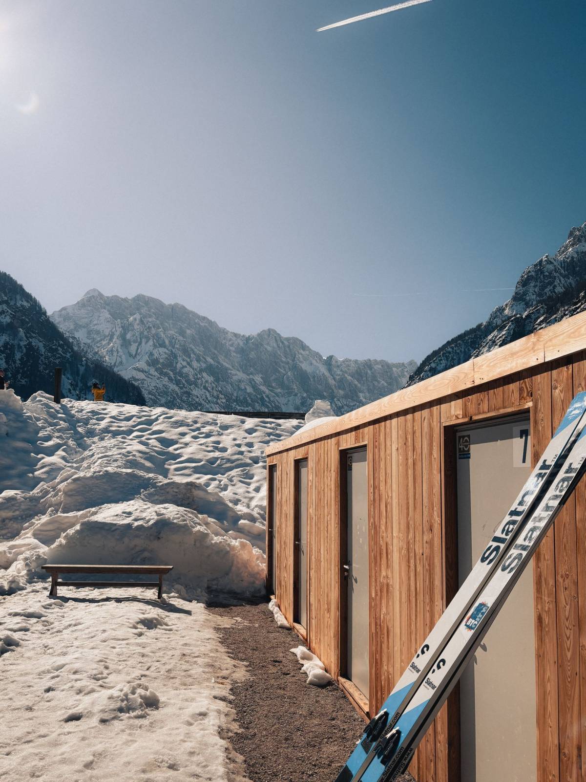 Skis posés devant un chalet en bois enneigé